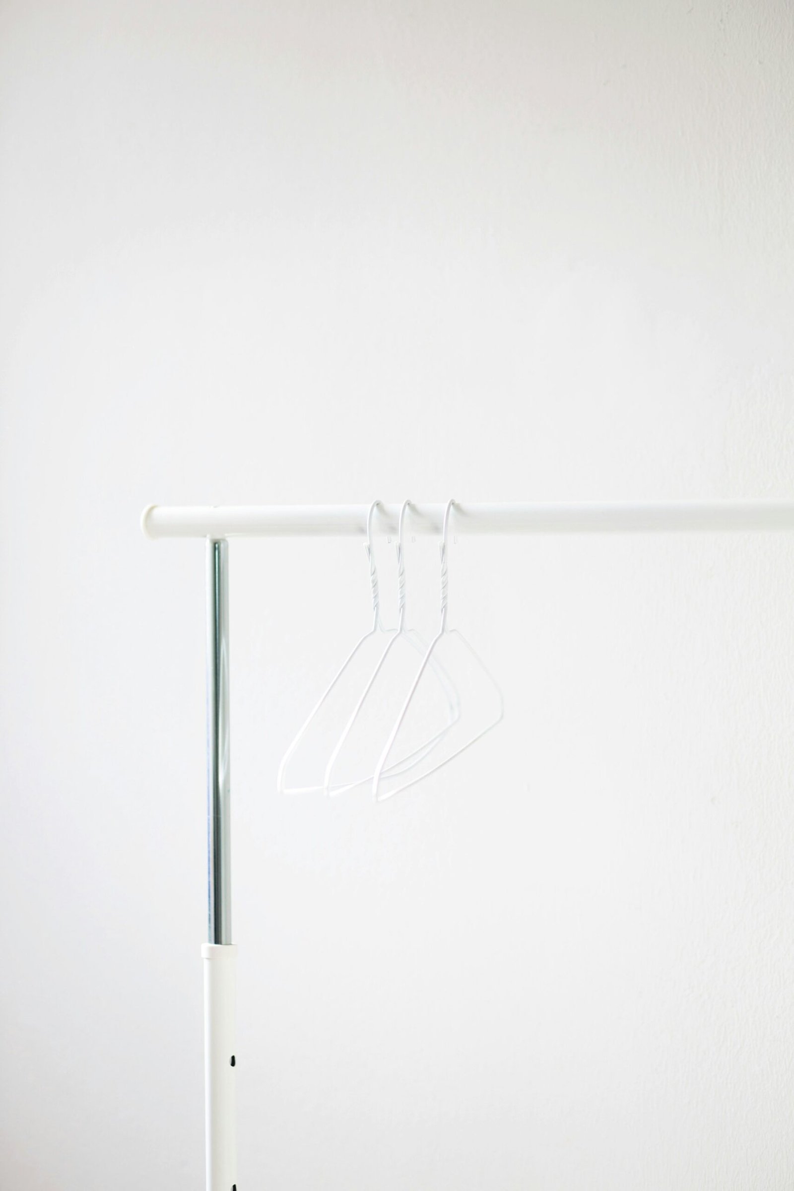 white clothes hanger on white metal bar